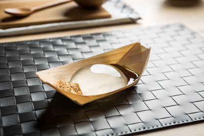 Raindrop Cake, clear jelly dessert on wooden boat. Asian dessert made of water and agar. Vegan and vegetarian.